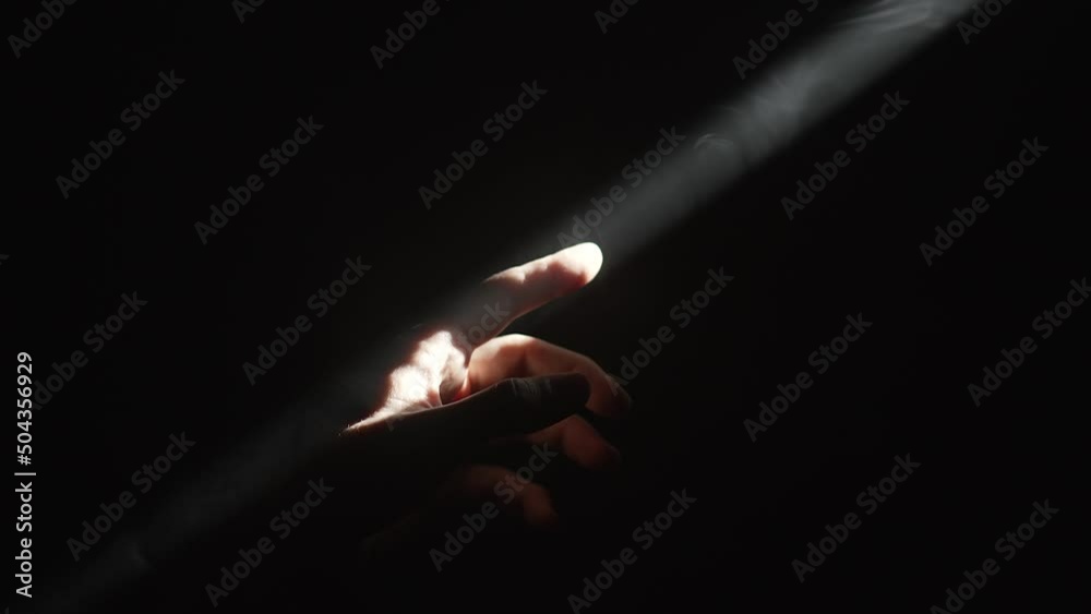 Hand touching a beam of light