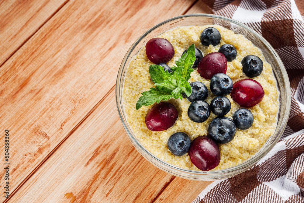 sweet porridge with quinoa and berries on a wooden rustic background sweet porridge with quinoa and berries on a wooden rustic background