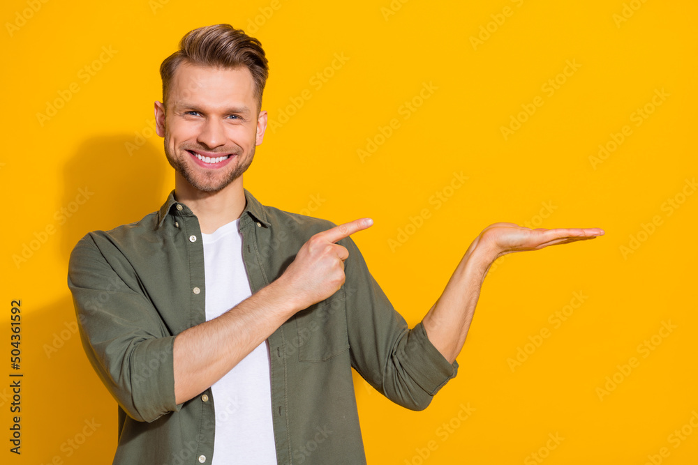 Portrait of attractive cheerful confident blond guy demonstrating copy space isolated over bright yellow color background Portrait of attractive cheerful confident blond guy demonstrating copy space isolated over bright yellow color background