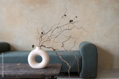 Tableau sur toile Dry branches in ceramic vase on vintage table