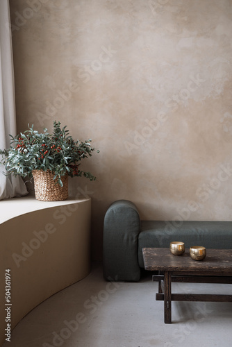 Modern soft couch, bronze bowls and decorative flowers photo