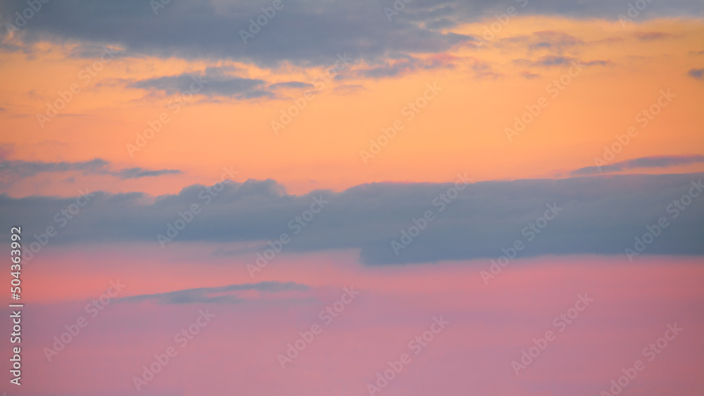 Pink orange sky with clouds at beautiful sunset as natural background.