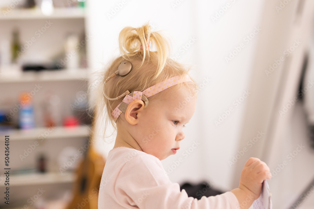 Cochlear implant for baby. Deaf child with hearing aid. Health care and medicine technology and innovations Cochlear implant for baby. Deaf child with hearing aid. Health care and medicine technology and innovations