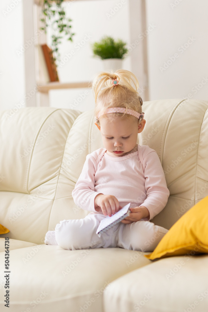 Baby with cochlear implants at home. Deafness and medical technology concept. Baby with cochlear implants at home. Deafness and medical technology concept.