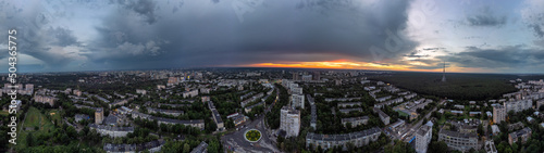 Epic wide sunset aerial urban panorama view in city residential district. Pavlovo Pole, Kharkiv, Ukraine. Evening skyscape, cloudscape and streets