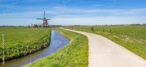 Panorama of a historic windmill and bicycl path near Sauwerd, Netherlands