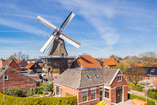 Historic windmill and typical dutch houses in Winsum, Netherlands