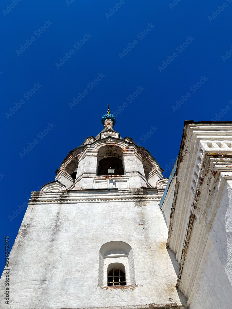 Old orthodox church with white walls, blue sky background 