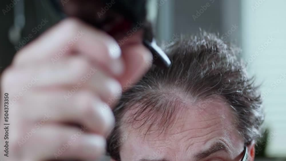 The man is drying his crazy hair, thinning hair. Slow motion video. The man is drying his crazy hair, thinning hair. Slow motion video.
