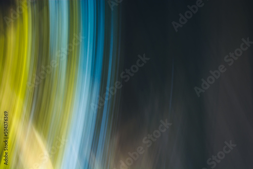 Abstract background in dark colors with blue and yellow-green twisted lines arcs.