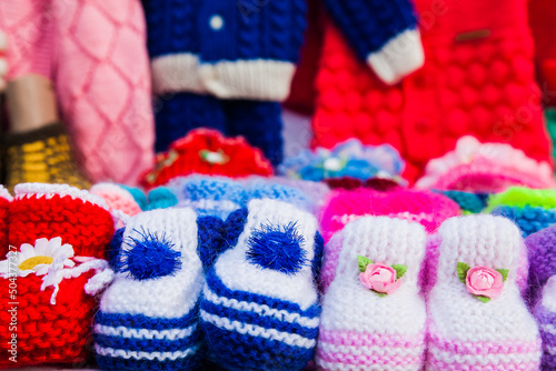 Knitted baby booties in other knitted things on the background