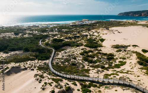 Aerial drone view of pedestrian path to Guincho Beach in Cascais, Portugal next to sand dunes photo