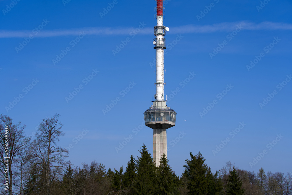 Obraz premium Communications tower at local mountain Uetliberg on a blue cloudy spring day. Photo taken April 14th, 2022, Zurich, Switzerland.