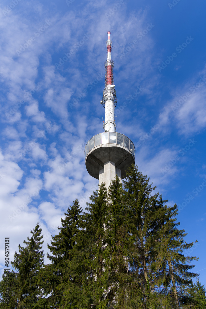 Obraz premium Communications tower at local mountain Uetliberg on a blue cloudy spring day. Photo taken April 14th, 2022, Zurich, Switzerland.