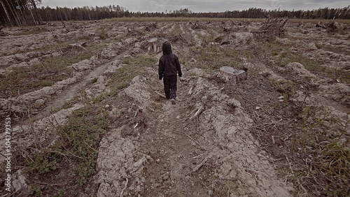 A boy walks among cut down trees. Russia. photo