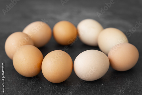 Organic chicken eggs on dark wooden background with copy space.