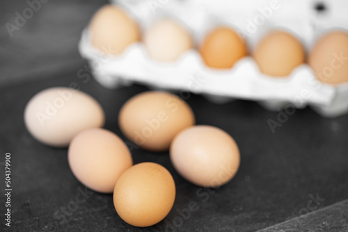 Eggs in basket. Brown chicken egges on wooden vintage table. Fresh egg on morning breakfast.