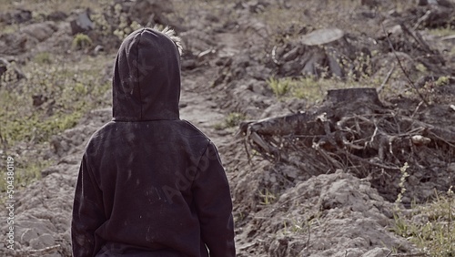 A boy walks among cut down trees. Russia. photo