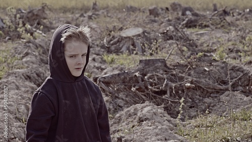A boy walks among cut down trees. Russia. photo