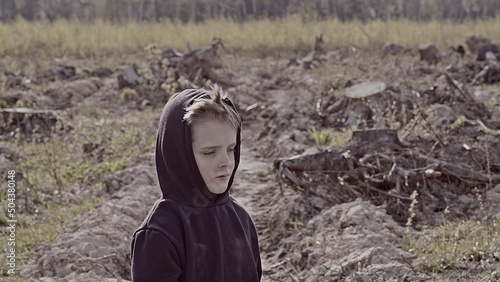 A boy walks among cut down trees. Russia. photo