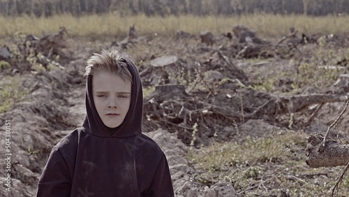 A boy walks among cut down trees. Russia. photo