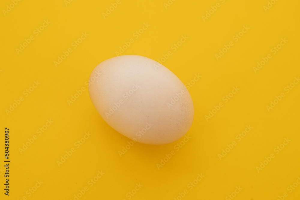 Raw eggs on yellow background