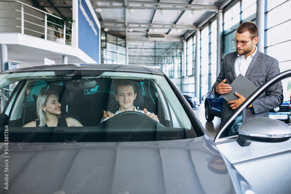 Young family buying a car in a car showroom Young family buying a car in a car showroom