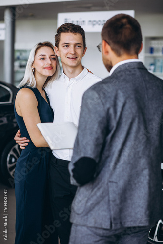 Young family buying a car in a car showroom
