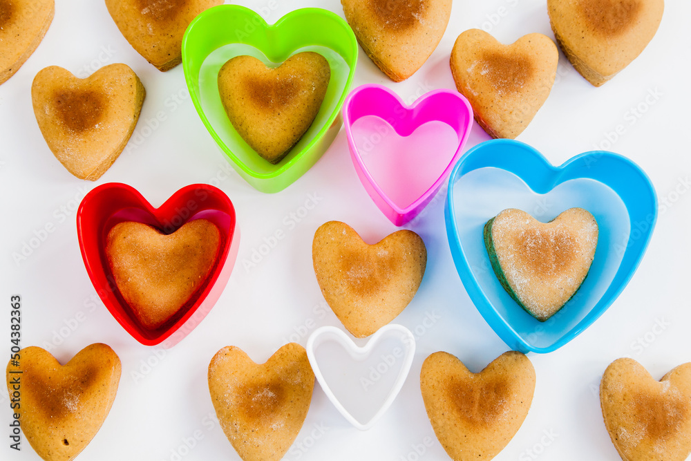 Heart shaped cookies on a white background with plastic shapes.