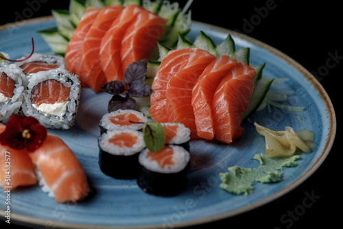 baked hot sushi rolls on a dark background. Hot fried Sushi Roll Sushi menu Set of sushi food with copy space Set of sushi with wasabi, soy sauce and teapot on black stone background