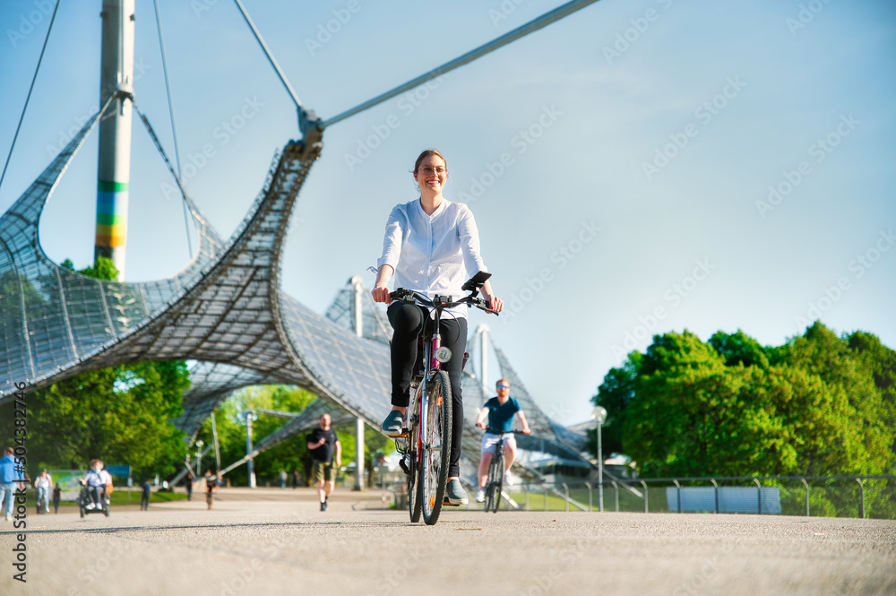 Fototapeta premium Woman rides a bicycle through the Olympic Park in Munich