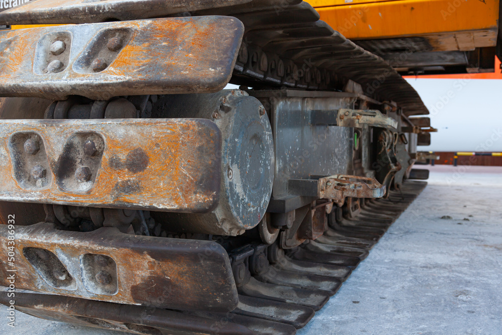 Close-up of metal tracks of a crawler crane with steel wheels. Chassis tracked vehicles.