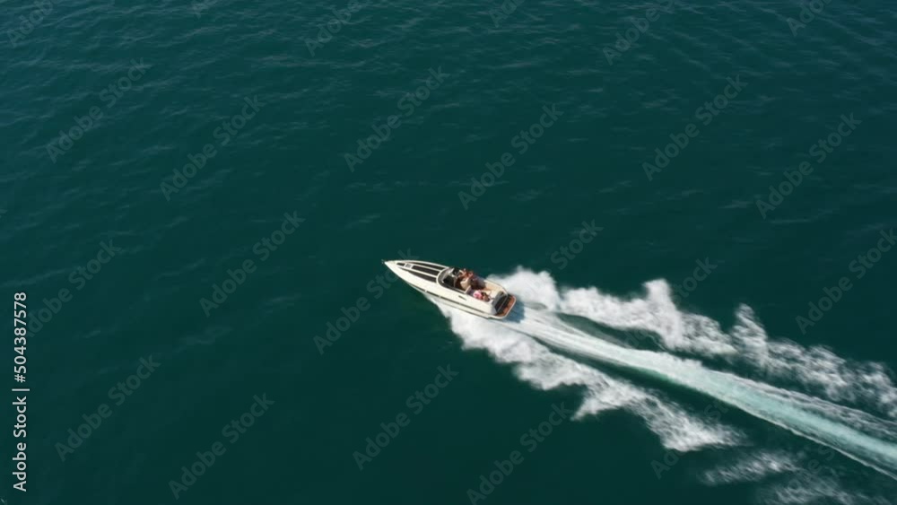 Speedboat moves fast on the water side view. Fast boat movements with people aerial view. Speedboat moves fast on the water side view. Fast boat movements with people aerial view.