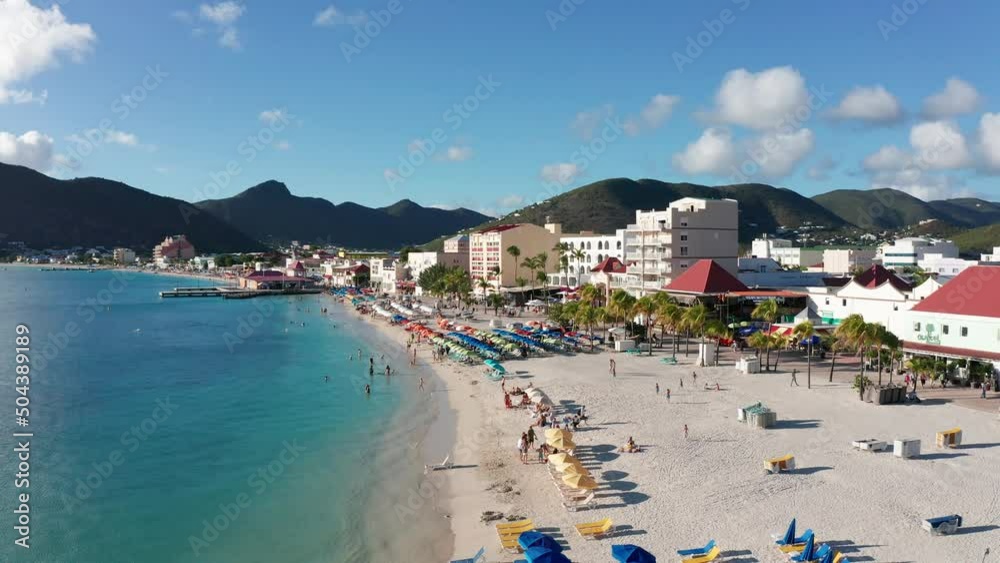 Low aerial close-up dolly shot of people having fun on the beach in the Caribbean. 4K Low aerial close-up dolly shot of people having fun on the beach in the Caribbean. 4K