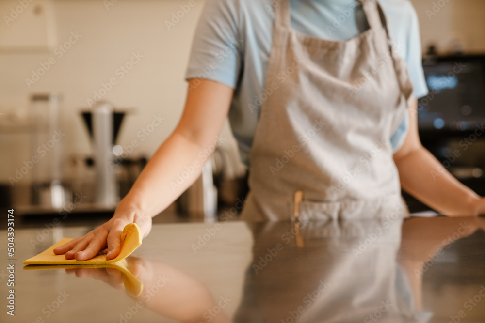 Young barista woman cleaning desk in cafe Young barista woman cleaning desk in cafe