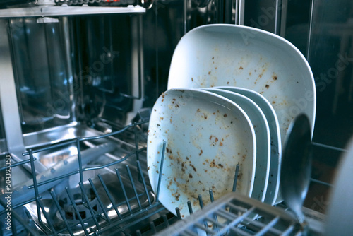 Dirty dishes in dishwashing machine. Making household easy. Technical progress helps keeping clean kitchen