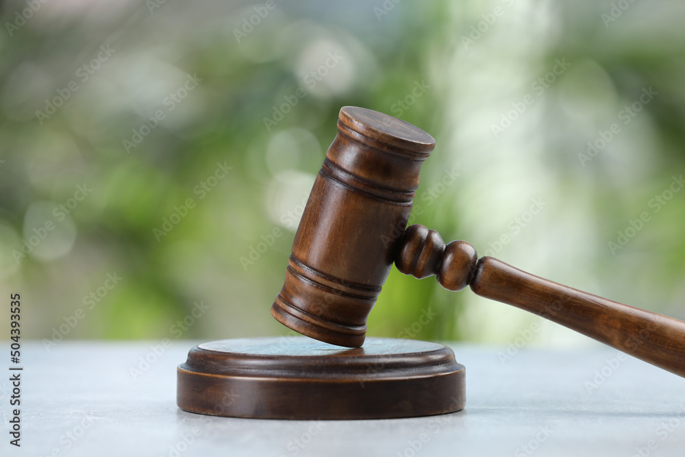 Wooden gavel on grey table against blurred background Wooden gavel on grey table against blurred background