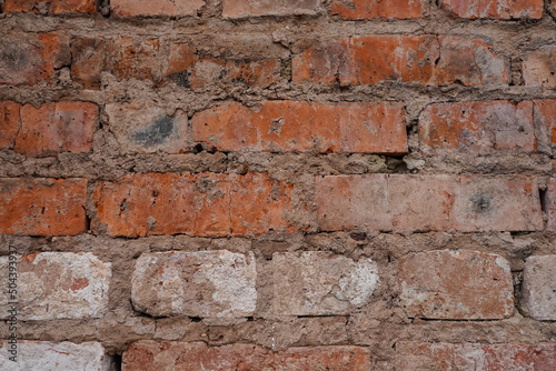 Red brick wall background with cracks between bricks