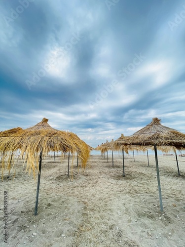 Straw beach umbrellas on a blue sky and sea background.Copy space  © Evis