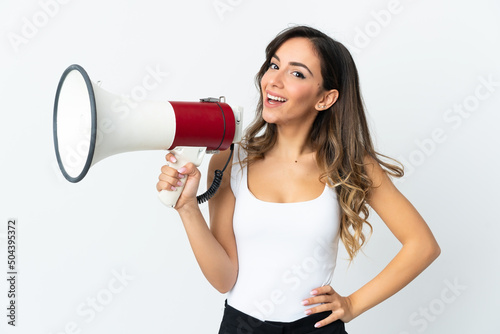 Young caucasian woman isolated on white background holding a megaphone and smiling