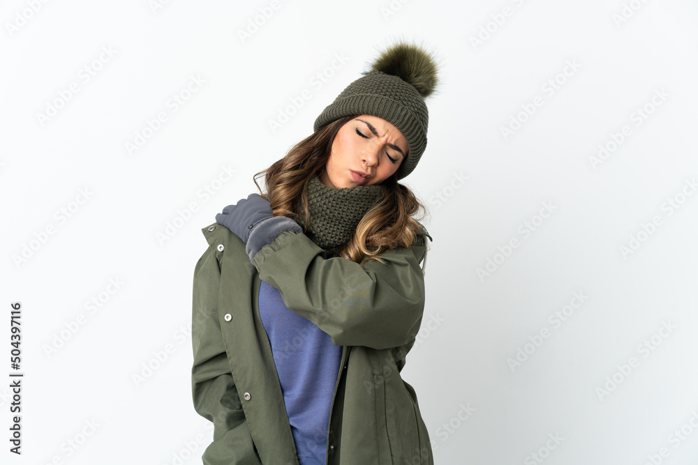 Young girl with winter hat isolated on white background suffering from pain in shoulder for having made an effort Young girl with winter hat isolated on white background suffering from pain in shoulder for having made an effort