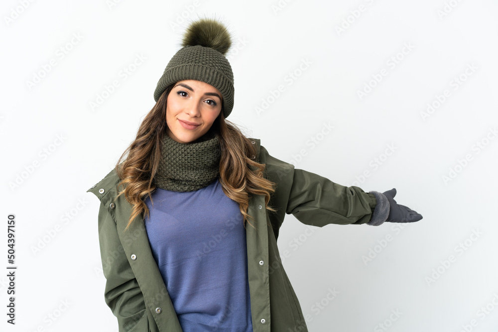 Young girl with winter hat isolated on white background extending hands to the side for inviting to come Young girl with winter hat isolated on white background extending hands to the side for inviting to come
