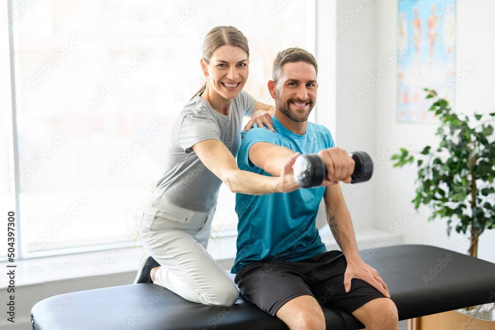 Obraz premium Modern rehabilitation physiotherapy woman worker with man client