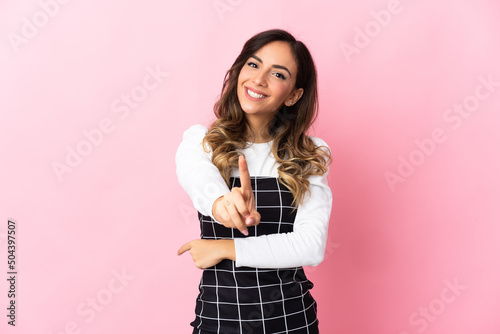 Young caucasian woman isolated on pink background showing and lifting a finger © luismolinero