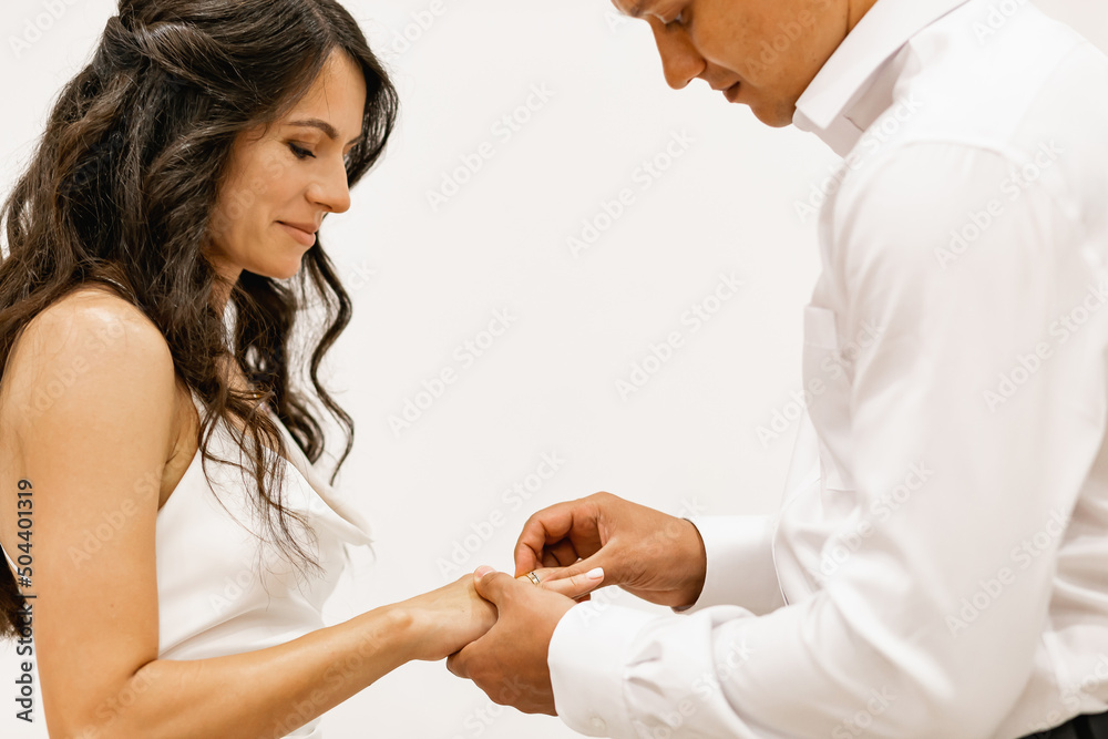 The moment of the exchange of wedding rings in the registry office. Happy wedding couple The moment of the exchange of wedding rings in the registry office. Happy wedding couple
