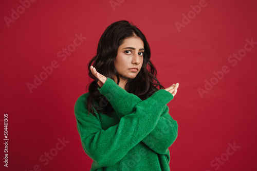 East asian woman wearing sweater showing stop gesture