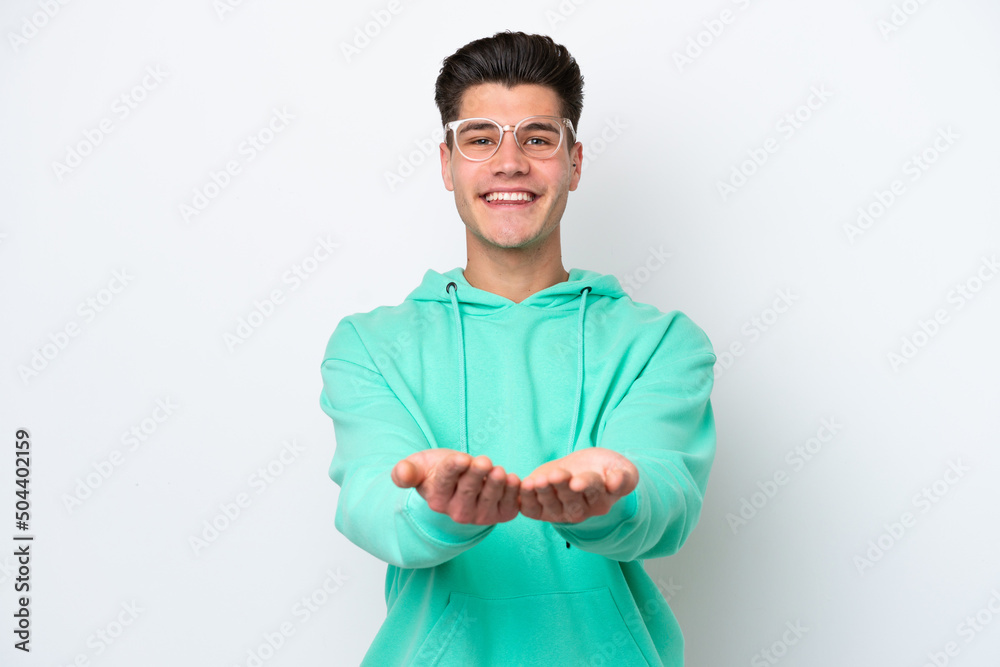 Young handsome caucasian man isolated on white bakcground holding copyspace imaginary on the palm to insert an ad Young handsome caucasian man isolated on white bakcground holding copyspace imaginary on the palm to insert an ad