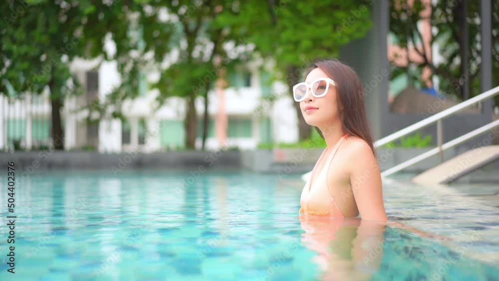 A young woman in a swimming pool looks around. Title space A young woman in a swimming pool looks around. Title space