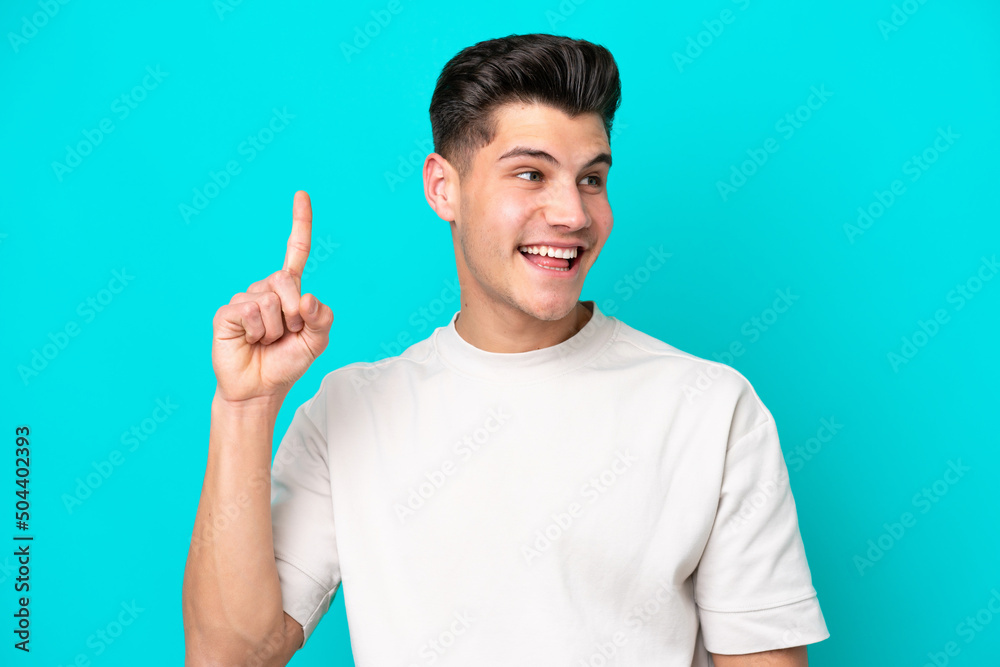 Young handsome caucasian man isolated on blue bakcground intending to realizes the solution while lifting a finger up Young handsome caucasian man isolated on blue bakcground intending to realizes the solution while lifting a finger up