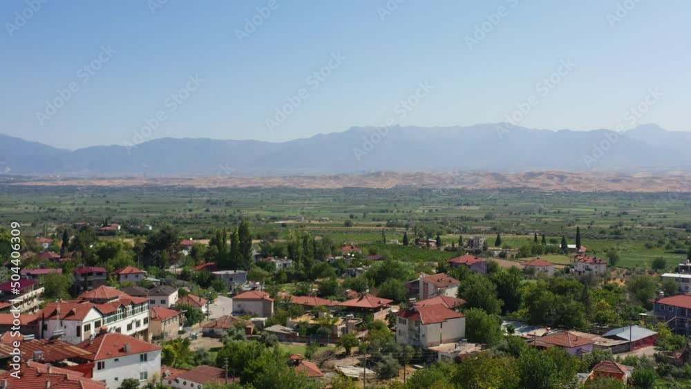 wide aerial view of a valley in southern Turkey with large mountains in the distance and a small village called Pamukkale wide aerial view of a valley in southern Turkey with large mountains in the distance and a small village called Pamukkale